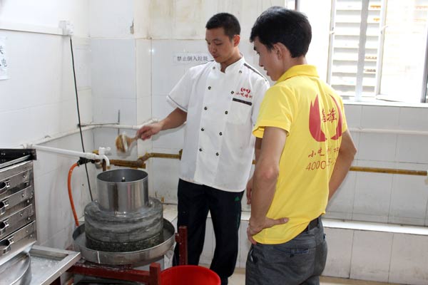 煌旗石磨肠粉培训老师教学生怎么用石磨机磨米浆